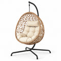 Poltrona sospesa in rattan con cuscino beige e struttura in metallo nero