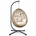 Sedia a dondolo con struttura in metallo e vimini sintetico, cuscini beige